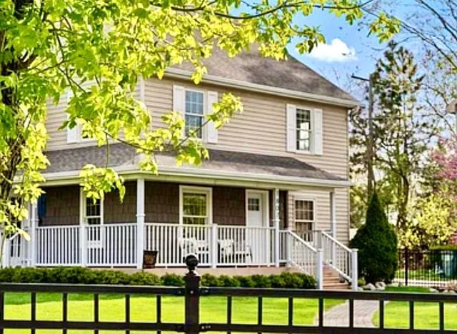 view of front of home featuring covered porch and a front yard