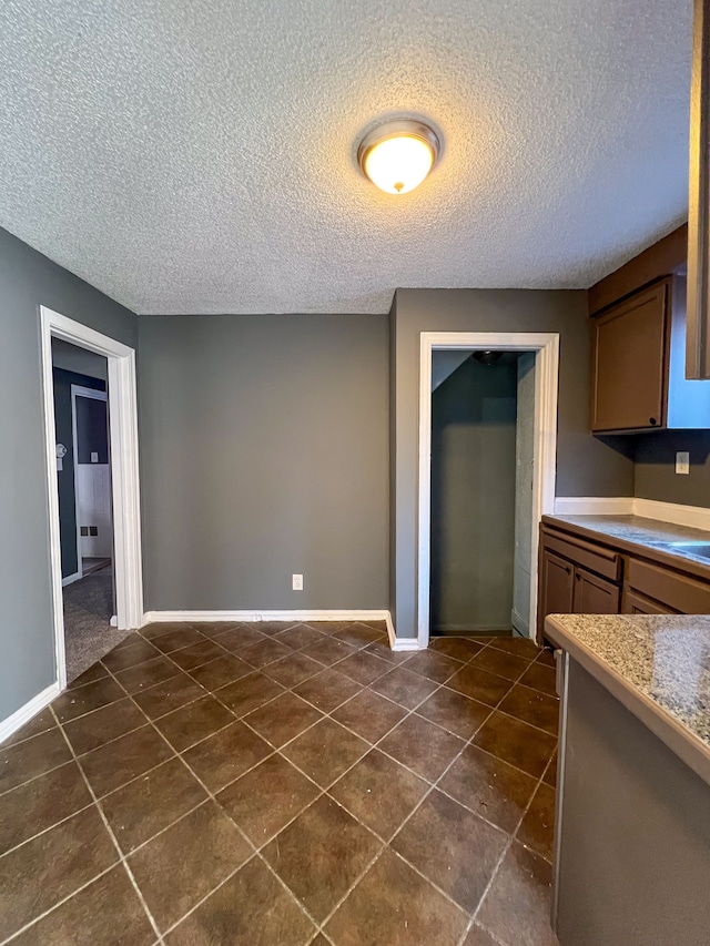 kitchen with dark tile patterned floors and a textured ceiling