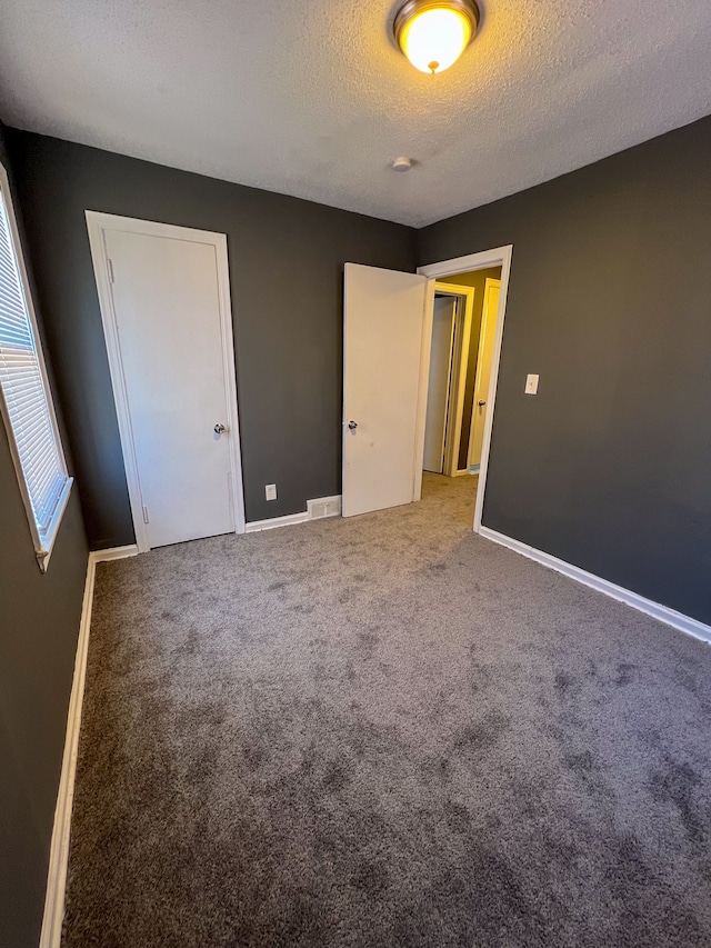 unfurnished bedroom featuring carpet flooring and a textured ceiling