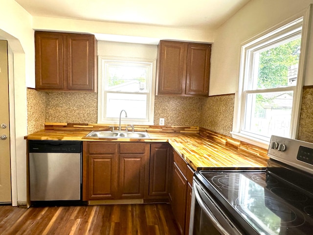 kitchen with a wealth of natural light, butcher block counters, and appliances with stainless steel finishes