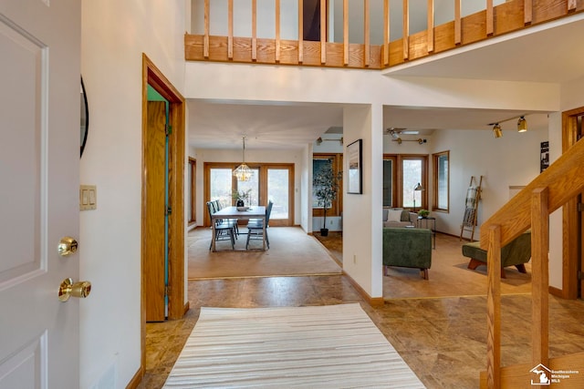 entryway with ceiling fan with notable chandelier