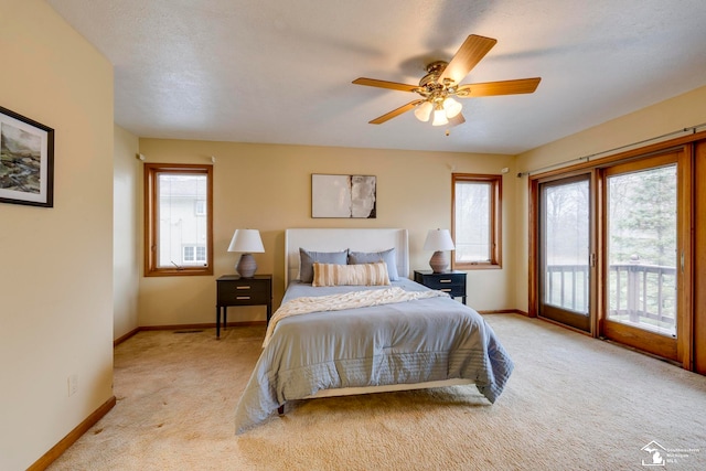 bedroom with a textured ceiling, ceiling fan, access to exterior, and light carpet