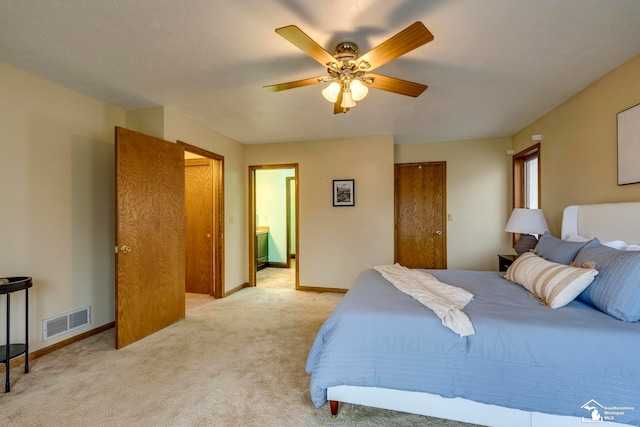 carpeted bedroom featuring ceiling fan and ensuite bathroom