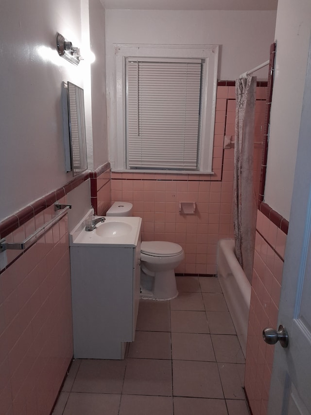 full bathroom featuring vanity, tile patterned flooring, toilet, shower / bath combo with shower curtain, and tile walls