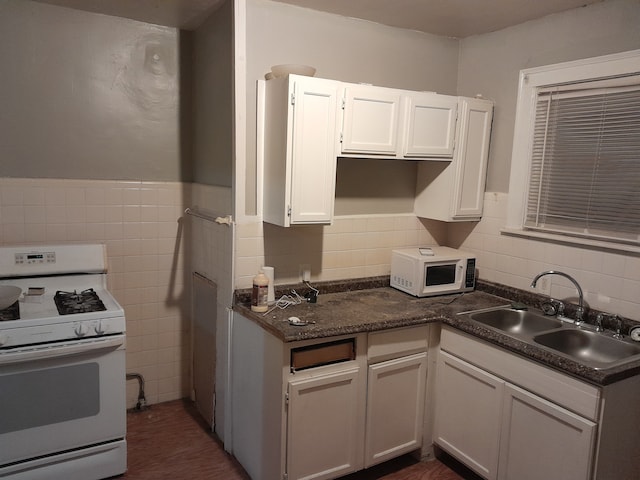 kitchen featuring dark hardwood / wood-style flooring, white appliances, sink, tile walls, and white cabinets