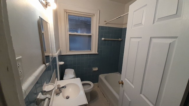 full bathroom with toilet, tiled shower / bath, tile patterned floors, and tile walls