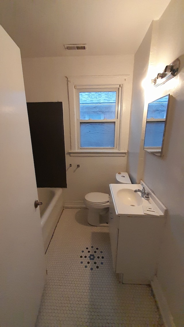 bathroom with a bathing tub, tile patterned flooring, vanity, and toilet