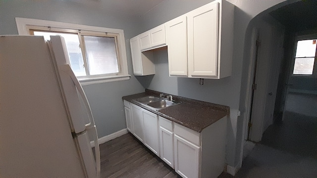 kitchen with a wealth of natural light, sink, white cabinets, and white refrigerator