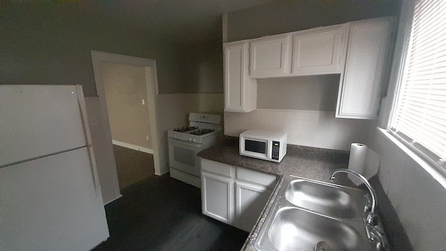 kitchen featuring a healthy amount of sunlight, white appliances, and white cabinetry