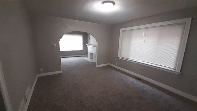 empty room featuring carpet floors and a brick fireplace