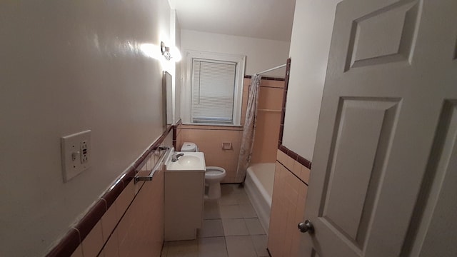 full bathroom with vanity, bathtub / shower combination, tile patterned floors, toilet, and tile walls