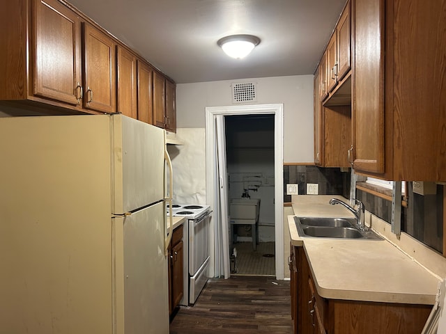 kitchen with tasteful backsplash, sink, dark wood-type flooring, and white appliances