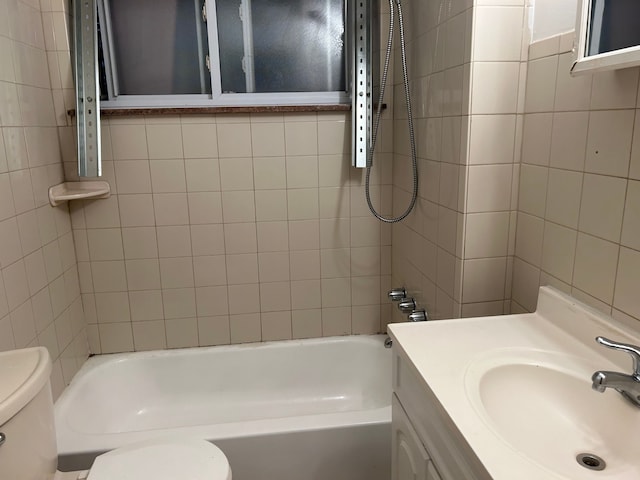 full bathroom featuring vanity, toilet, and tiled shower / bath