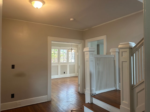 interior space featuring hardwood / wood-style flooring, crown molding, and a notable chandelier