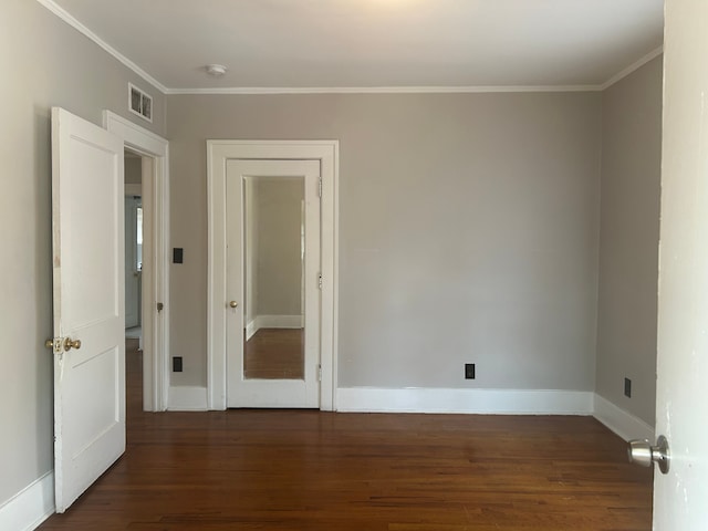 empty room with crown molding and dark hardwood / wood-style floors