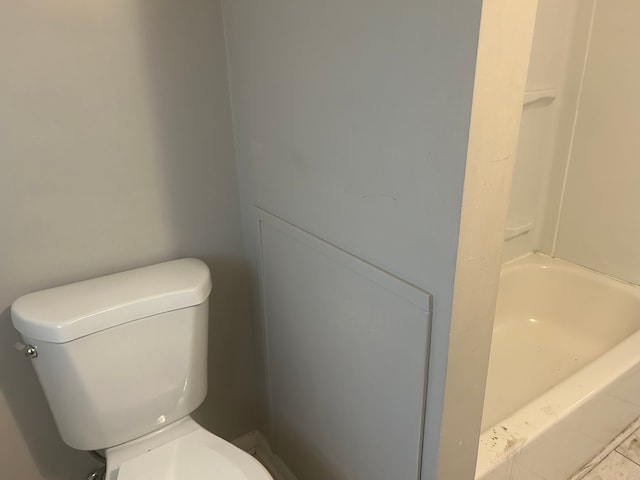 bathroom with a bathing tub, tile patterned flooring, and toilet