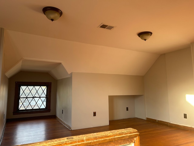 additional living space featuring lofted ceiling and dark wood-type flooring