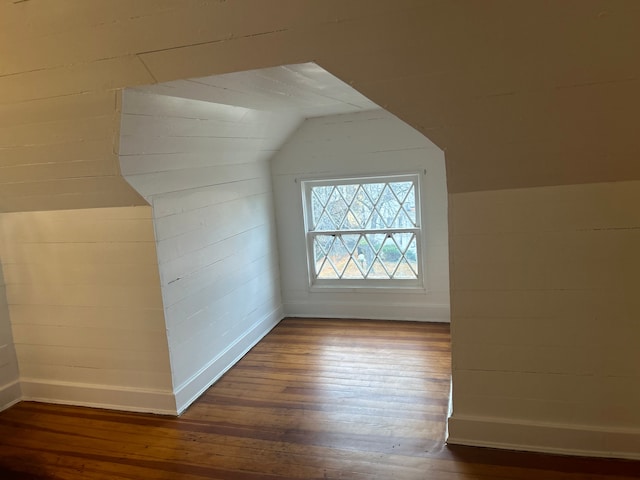 additional living space with dark hardwood / wood-style floors and vaulted ceiling