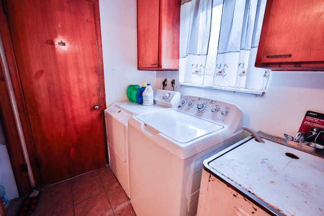 laundry room with dark tile patterned floors, cabinets, and independent washer and dryer