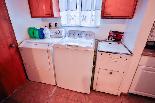 laundry area with washing machine and dryer, light tile patterned floors, and cabinets