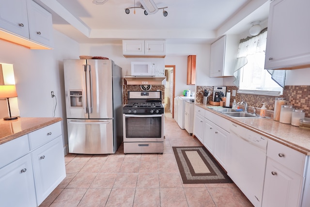 kitchen with backsplash, white cabinetry, sink, and stainless steel appliances