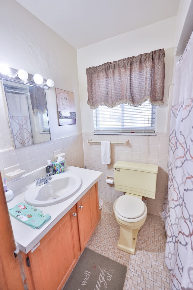 bathroom featuring vanity, tile walls, and toilet