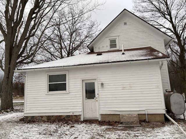 view of snow covered rear of property