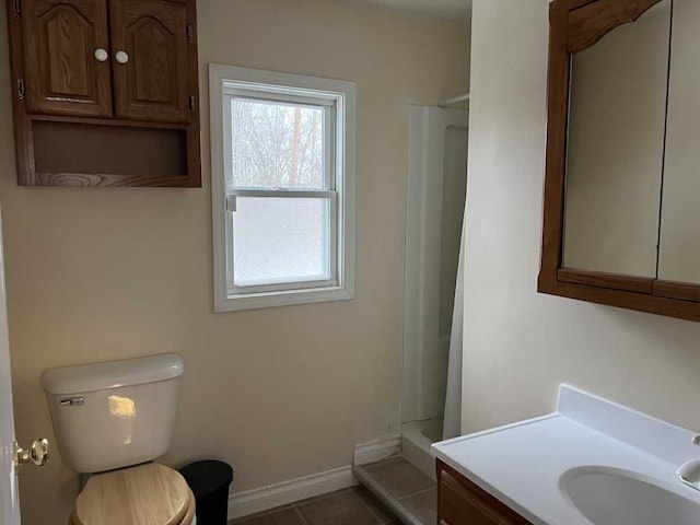 bathroom with vanity, tile patterned floors, toilet, and walk in shower