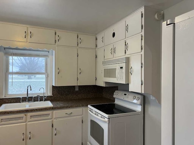 kitchen with white appliances, sink, and white cabinets