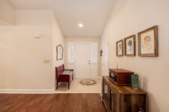 entryway with dark hardwood / wood-style flooring and lofted ceiling