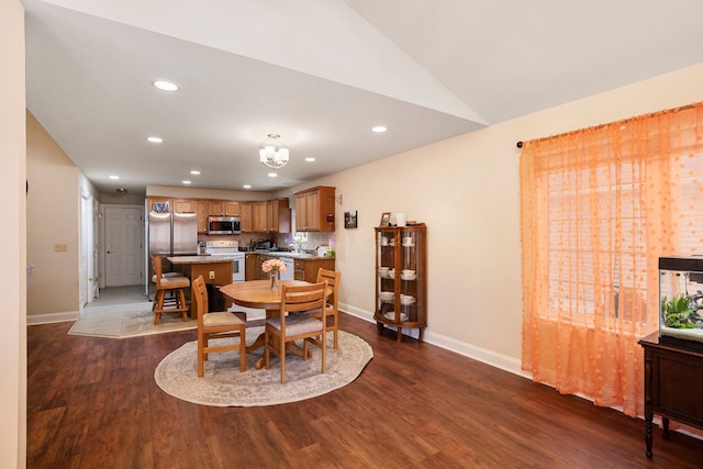 dining area with lofted ceiling and dark hardwood / wood-style floors