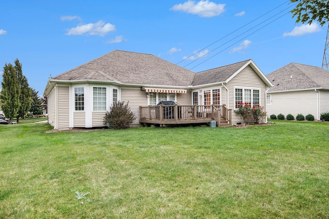 rear view of property featuring a lawn and a wooden deck