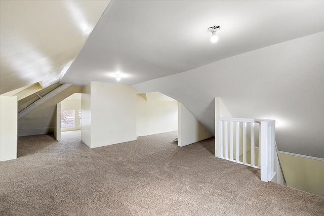 additional living space featuring lofted ceiling and light carpet