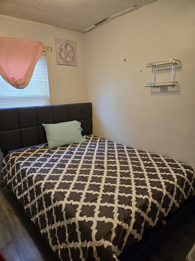 bedroom with a textured ceiling and dark wood-type flooring