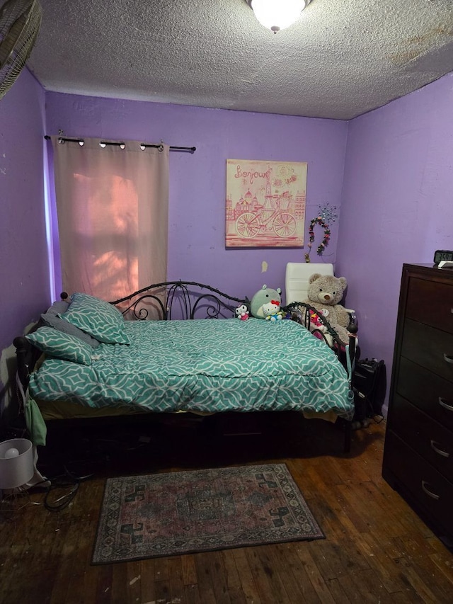 bedroom featuring wood-type flooring and a textured ceiling