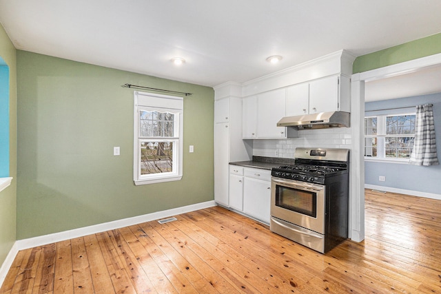 kitchen with decorative backsplash, light hardwood / wood-style flooring, white cabinets, and stainless steel range with gas stovetop