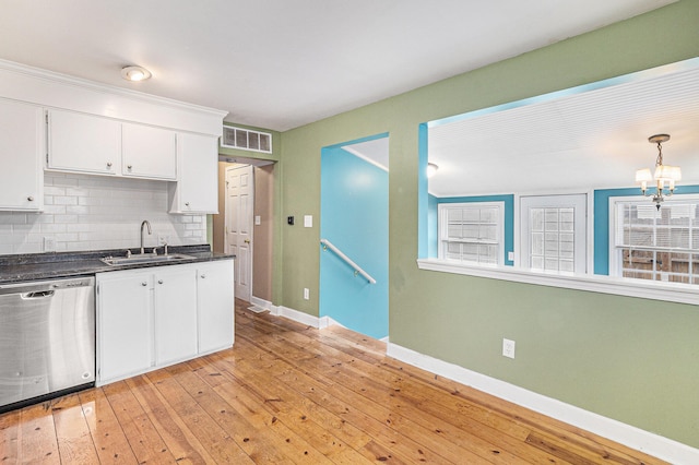 kitchen featuring white cabinets, sink, stainless steel dishwasher, decorative backsplash, and light wood-type flooring