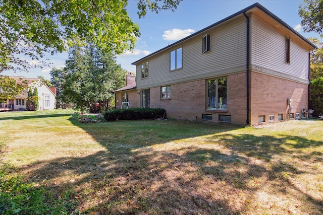 rear view of property featuring a lawn