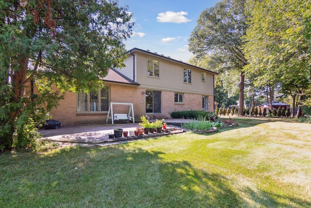 rear view of house with a yard and a patio