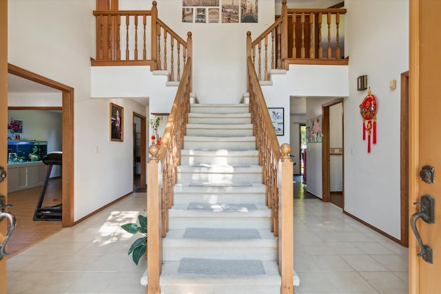 stairs featuring a high ceiling and hardwood / wood-style floors