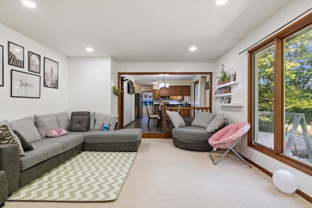 carpeted living room featuring a notable chandelier