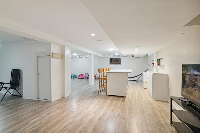 kitchen featuring a kitchen breakfast bar and light hardwood / wood-style floors