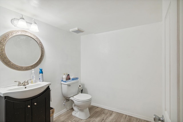 bathroom with hardwood / wood-style flooring, vanity, and toilet