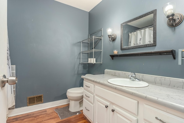 bathroom featuring vanity, hardwood / wood-style flooring, and toilet