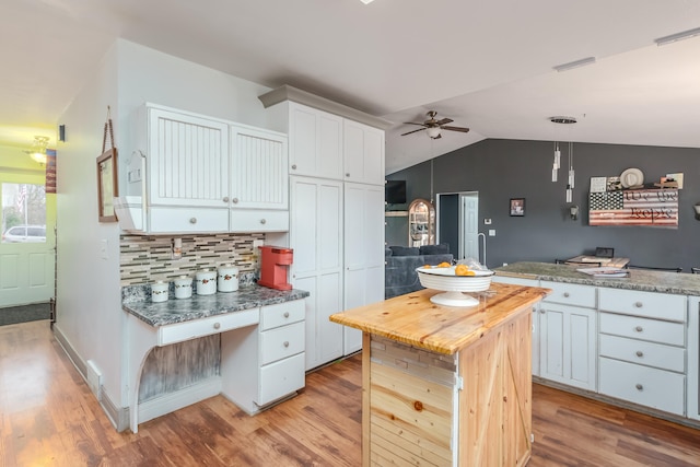 kitchen with decorative light fixtures, white cabinetry, and light hardwood / wood-style flooring