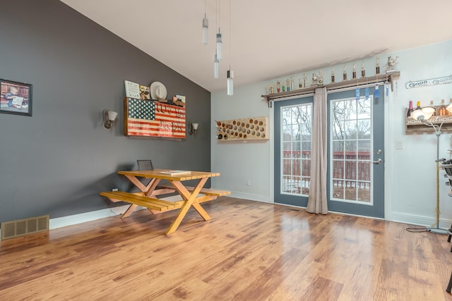 dining area with wood-type flooring and lofted ceiling