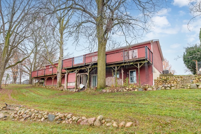 rear view of property featuring a wooden deck and a yard