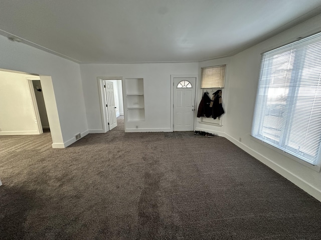 entryway with a healthy amount of sunlight and dark carpet