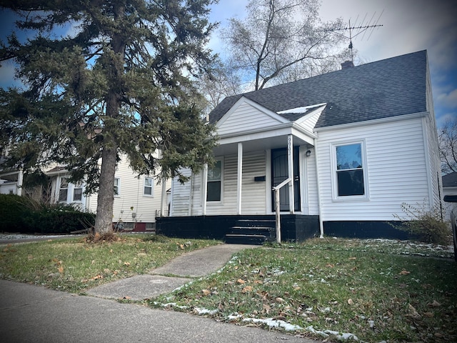 bungalow featuring covered porch and a front lawn