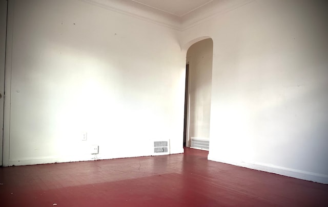 empty room featuring crown molding and dark wood-type flooring